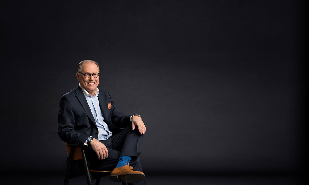 Suomen Yritysmyynnin yritysvälittäjä, Jukka Tuunanen, istuu puku päällä rennosti tuolilla ja hymyilee kameralle.