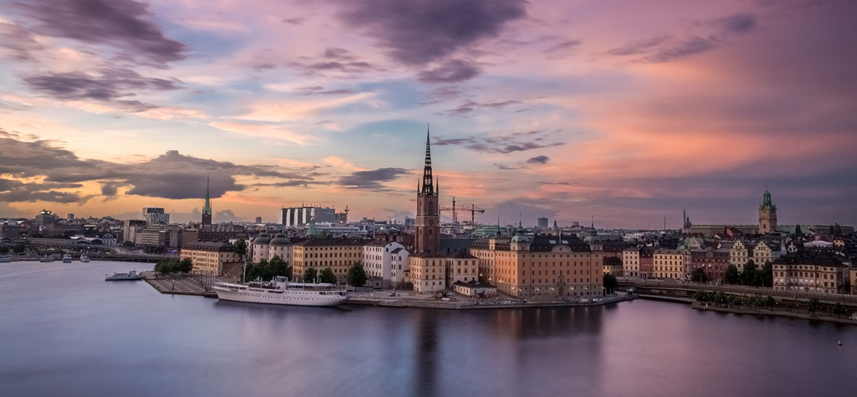 Tukholman vanha kaupunki kuvattuna yläviistosti ilmasta. Kuvassa näkyy mm. vanha laiva, korkeita rakennusten torneja ja meri.